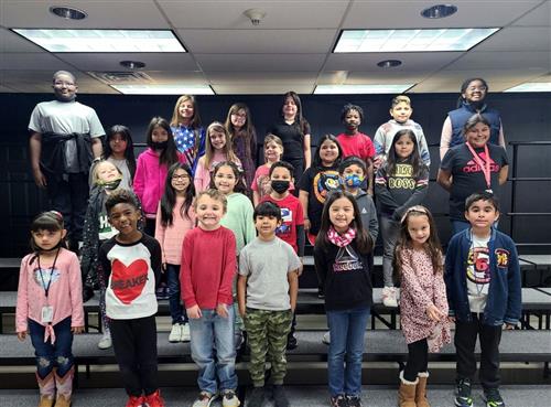 group of elementary students on stage stairs