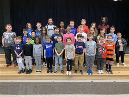 group of elementary students on stage stairs